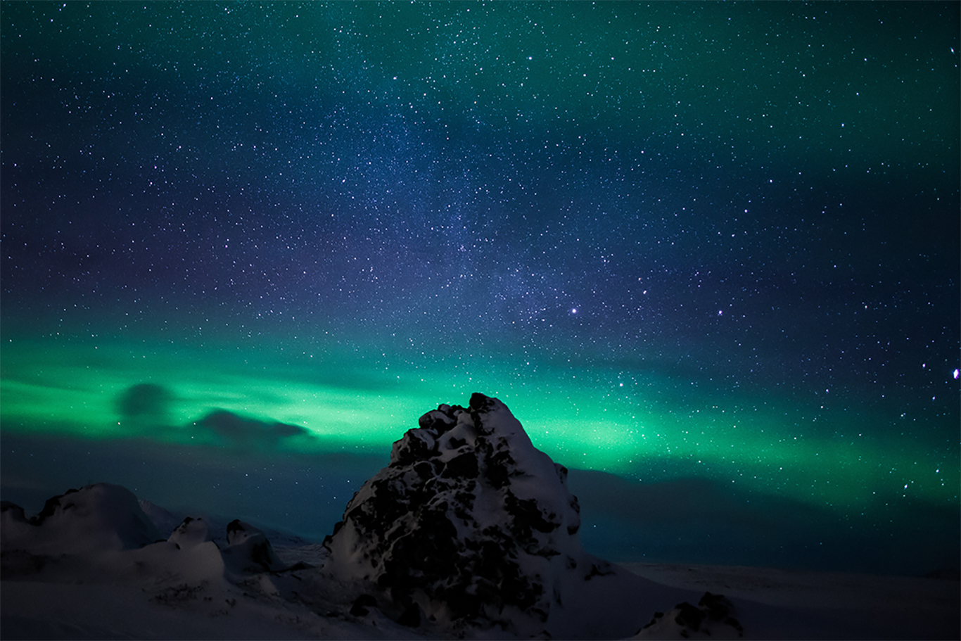 <p>Photo courtesy <a href="https://instagram.com/ellithorphotography/">Elli Thor Magnusson</a> for Arctic Adventures.</p> Green northern lights glowing across a dark night sky above an Arctic landscape