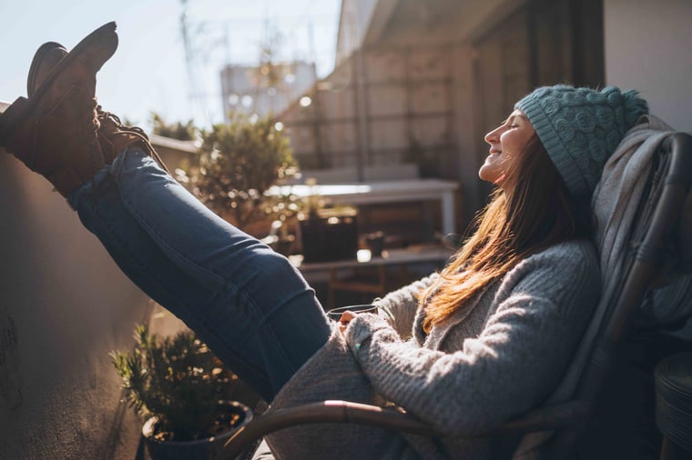 Person smiling and leaning back with legs up 