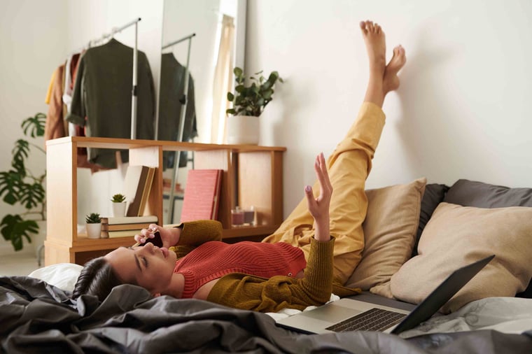 Person laying in bed on the phone
