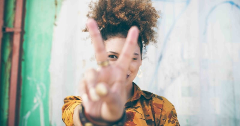 Person giving the peace sign to camera